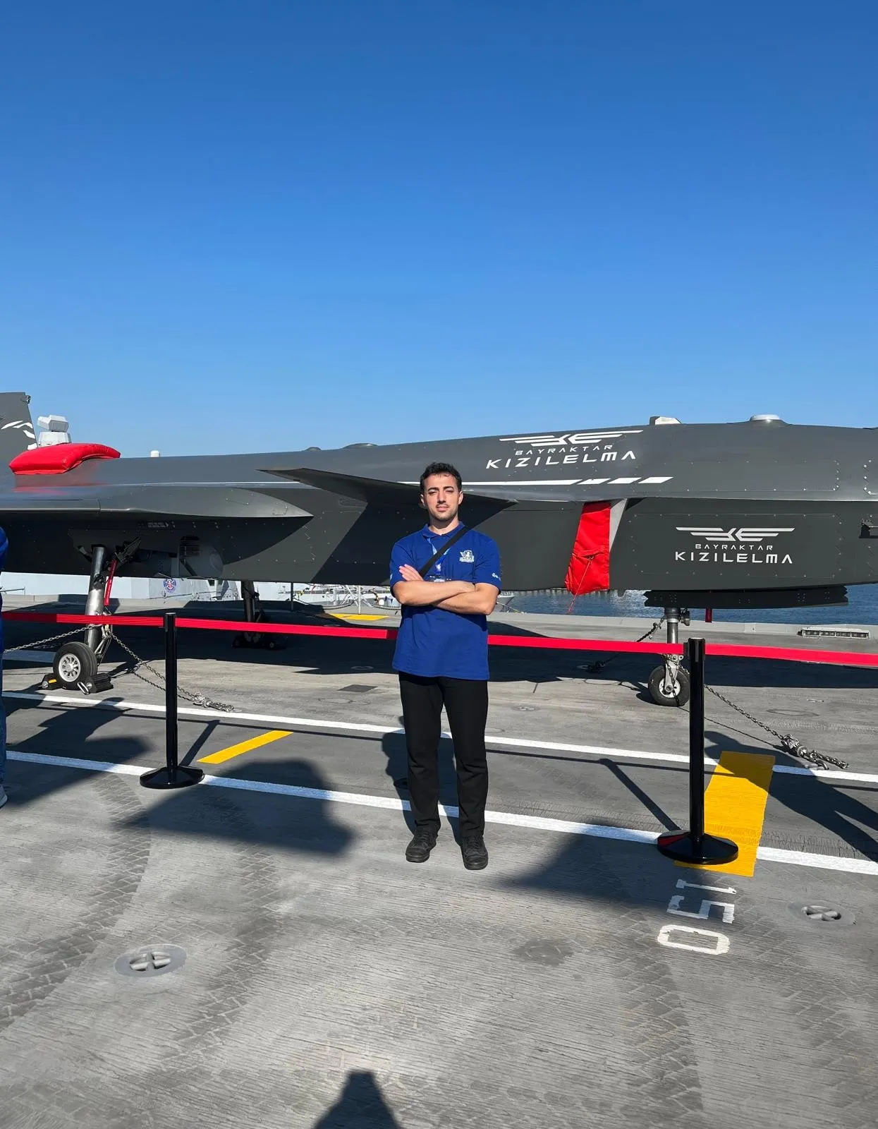 Standing in front of the Bayraktar KIZILELMA unmanned fighter aircraft